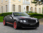AUT 48 RK0106 01
2012 Bentley Continental Supersports ISR Convertible Black And Red 3/4 Front View On Brick By Mansion