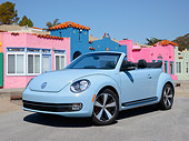 AUT 49 RK0011 01
2013 Volkswagen Beetle Covertible Turbo 60s Light Blue 3/4 Front View On Pavement By Colorful Buildings