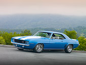 CAM 01 RK0202 01
1969 Chevrolet Camaro Z-28 Blue With White Stripe 3/4 Front View On Pavement By Trees And Fog