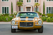 CAM 01 RK0208 01
1970 1/2 Chevrolet Camaro Z-28 Gold With Black Stripe Head On View On Pavement By House