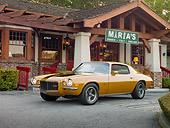 CAM 01 RK0210 01
1970 1/2 Chevrolet Camaro Z-28 Gold With Black Stripe 3/4 Front View On Pavement By Storefront