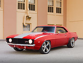 CAM 01 RK0232 01
1969 Chevrolet Camaro Z-28 Red With Gray Stripe 3/4 Front View On Pavement By Building
