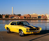 CAM 01 RK0096 07
1969 Camaro Z-28 Rally Sport Yellow Black Stripes 3/4 Front View On Pavement By Water At Dusk