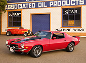 CAM 01 RK0119 01
1973 Chevrolet Camaro Z-28 Red And Black 3/4 Front View On Pavement By Garage