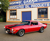 CAM 01 RK0120 01
1973 Chevrolet Camaro Z-28 Red And Black 3/4 Front View On Pavement By Garage