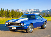 CAM 03 BK0002 01
1968 Chevrolet Camaro Blue With White Stripe 3/4 Front View On Road By Pine Trees And Snow-Covered Mountains