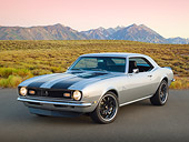 CAM 03 RK0252 01
1968 Chevrolet Camaro Silver With Black Stripes 3/4 Front View On Pavement By Field And Mountains