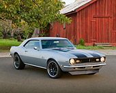 CAM 03 RK0253 01
1968 Chevrolet Camaro Silver With Black Stripes 3/4 Front View On Pavement By Red Barn