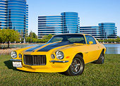 CAM 04 RK0252 01
1971 Chevrolet Camaro High Velocity Yellow With Charcoal Pearl Stripes 3/4 Front View On Grass By Glass Buildings