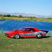 CAM 04 RK0033 04
1967 Red & Black Chevy Camaro Blow Fuel Dragster 3/4 Front View On Grass By Water And Trees