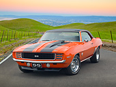 CAM 07 RK0132 01
1969 Chevrolet Camaro RS/SS Hugger Orange With Black Stripes 3/4 Front View On Road By Grassy Hills At Dusk