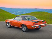 CAM 07 RK0133 01
1969 Chevrolet Camaro RS/SS Hugger Orange With Black Stripes 3/4 Rear View On Road By Grassy Hills At Dusk