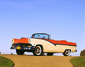 AUT 21 RK0825 09
1956 Ford Fairlane Sunliner Convertible Red & White Low 3/4 Side View On Pavement By Grass Blue Sky