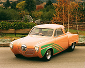 AUT 21 RK0832 05
1951 Studebaker Street Rod Peach And Green 3/4 Front View On Pavement By Trees And Flowers Headlights On