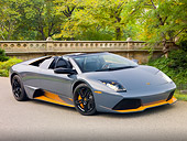 LAM 01 RK0752 01
2010 Lamborghini Murcielago LP650 Roadster Gray And Orange 3/4 Front View On Pavement By Trees And Bridge