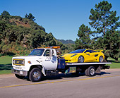 LAM 01 RK0016 01
Yellow Lamborghini Cala Italdesign On Tow Truck Driving On Road By Grass Blue Sky