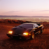 LAM 01 RK0072 08
Lamborghini Countach Black 3/4 Front View In Field At Dusk Above City Lights
