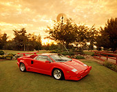 LAM 01 RK0171 01
1989 Lamborghini Countach 25th Anniversary Red 3/4 Front View On Grass By Trees Clouds Sunset