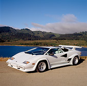 LAM 01 RK0177 04
Lamborghini Countach White 3/4 Front View On Pavement By Lake Hills Blue Sky Clouds