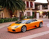 LAM 01 RK0462 09
2002 Lamborghini Murcielago Orange 3/4 Front View On Driveway By Building