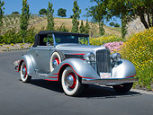 AUT 19 RK1033 01
1934 Pontiac Convertible Silver With Red Trim 3/4 Front View On Pavement By Trees And Flowers