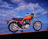 MOT 01 RK0330 01
1973 Triumph Hurricane Orange 3/4 Side View On Orange Line Cloudy Blue Sky Background