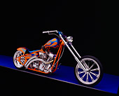 MOT 04 RK0019 04
2003 Riff Raff Custom Chopper Orange Blue Flames Side 3/4 View On Purple Floor Gray Line Studio