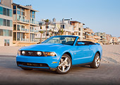 MST 01 RK1240 01
2011 Ford Mustang GT Convertible Blue 3/4 Front View On Pavement By Beach Houses