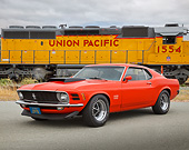 MST 01 RK1600 01
1970 Ford Mustang Boss 429 Calypso Coral 3/4 Front View On Pavement By Train