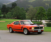 MST 01 RK0185 07
1970 Ford Mustang Boss 302 Calypso Coral 3/4 Front View On Pavement  By Grass Trees Hills