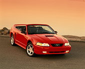 MST 01 RK0318 05
2000 Ford Mustang GT Convertible Red 3/4 Front View On Pavement  Headlights On Orange Sky