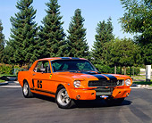 MST 01 RK0507 02
1966 Ford Mustang Coupe Orange With Black Stripe 3/4 Front View On Pavement By Trees Blue Sky