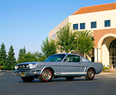MST 01 RK0516 01
1966 Ford Mustang Fastback GT Blue Low 3/4 Side View On Pavement By Building And Trees Blue Sky