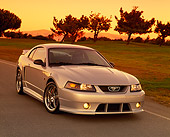 MST 01 RK0552 05
2001 Roush Mustang Stage 3 Silver 3/4 Front View On Pavement By Grass And Trees Yellow Sky