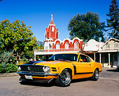 MST 01 RK0724 02
1970 Ford Mustang Boss 302 Orange Black Stripe Low 3/4 Front View On Pavement By Buildings