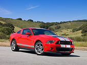 MST 03 RK0884 01
2010 Ford Shelby Mustang GT500 Red And Silver Stripe 3/4 Front View On Pavement By Hills