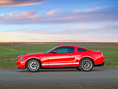 MST 03 RK0915 01
2011 Shelby Ford Mustang GT500 SVT Red With White Stripes Profile View On Pavement At Dusk
