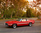 MST 03 RK0132 05
1969 Shelby GT350 Convertible Orange And White Stripe 3/4 Side View On Pavement By Trees