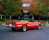 MST 03 RK0135 02
1969 Shelby GT350 Convertible Orange With White Stripe Low 3/4 Rear View On Pavement By Building