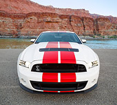 MST 04 RK0051 01
2013 Ford Mustang GT500 White With Red Stripes Front View On Pavement By Water And Red Rock