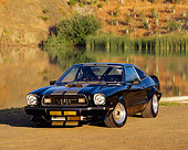 MST 04 RK0003 02
1977 Ford Mustang Cobra II Black Gold Stripe 3/4 Front View On Dirt By Water