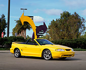 MST 04 RK0010 04
1998 Ford Mustang Cobra Yellow 3/4 Front View On Pavement By Arrows Blue Sky Trees