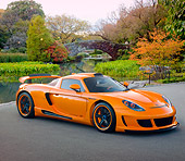 POR 04 RK0855 01
2008 Porsche Gemballa Mirage GT Orange 3/4 Front View On Pavement By Pond And Trees