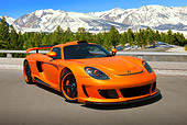 POR 04 RK0900 01
2008 Porsche Gemballa Mirage GT Orange 3/4 Front View On Pavement By Pine Trees And Snow-Covered Mountains