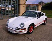 POR 04 RK0523 02
1973 Porsche 911 Carrera RS White 3/4 Front View On Pavement By Gate