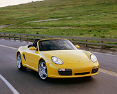 POR 04 RK0586 02
2004 Porsche Boxster S Convertible Yellow 3/4 Front View On Road By Grass Hills