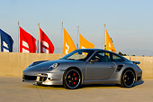 POR 04 RK0669 01
2007 Porsche 911 Turbo Silver 3/4 Side View On Pavement By Flags