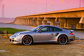 POR 04 RK0678 01
2007 Porsche 911 Turbo Silver 3/4 Front View By Bridge And Water At Sunset