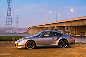 POR 04 RK0679 01
2007 Porsche 911 Turbo Silver 3/4 Front View By Bridge And Water
