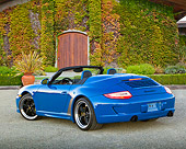 POR 07 RK0130 01
2011 Porsche 911 Speedster Convertible Blue 3/4 Rear View On Gravel By Ivy Covered Building